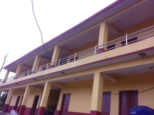 The finished upper veranda of the school running the length of the building, with steel balustrade and painted columns.
